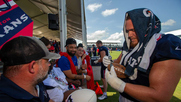 OT Austin Deculus signs an autograph for a fan at Texans' training camp